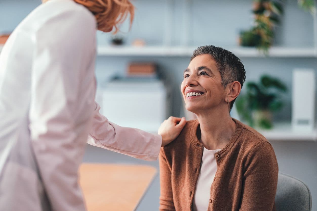 A patient smiling during a hearing consultation with her audiologist