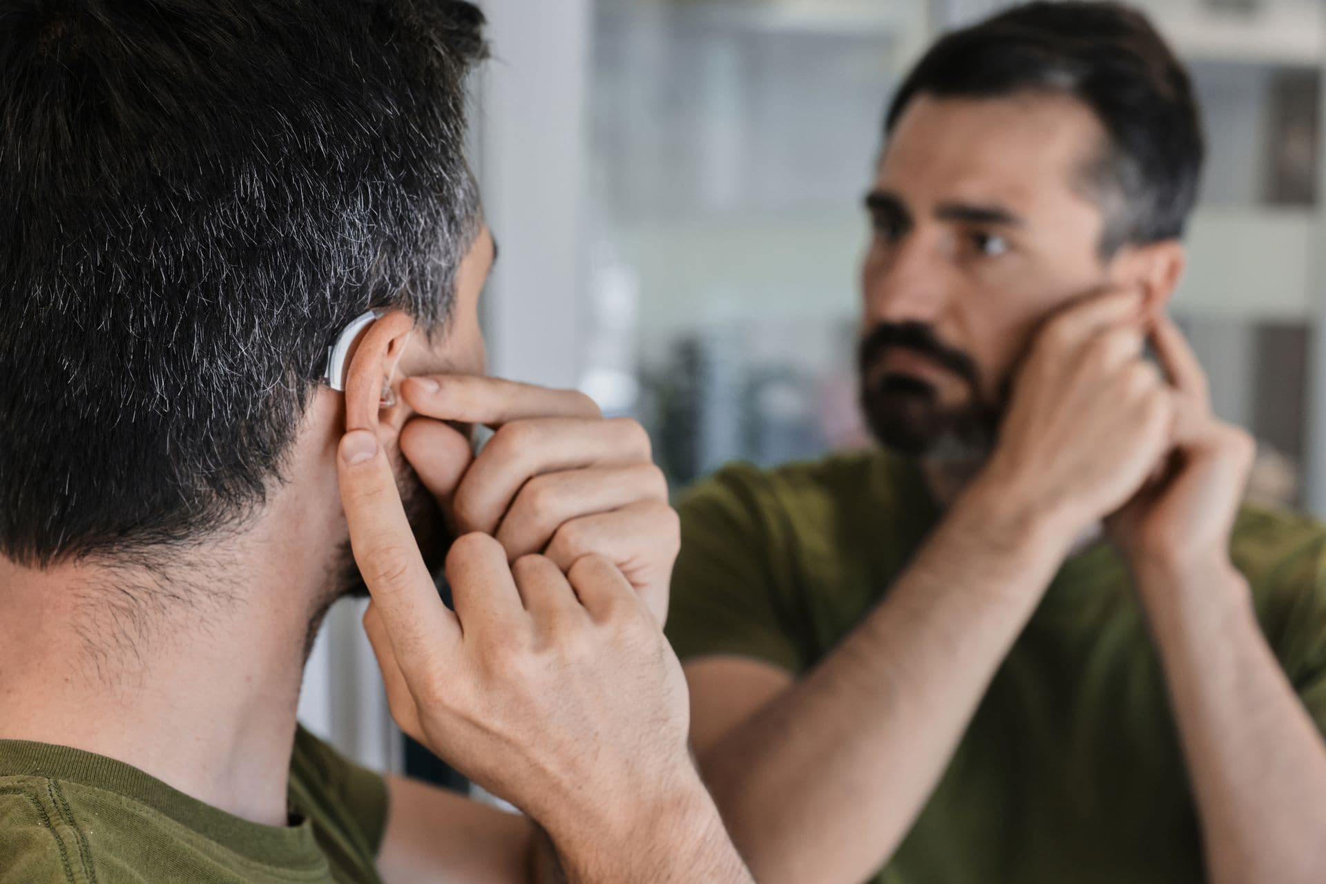 Man placing a hearing aid in his ear